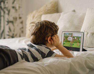 Un enfant lit ou écoute une histoire sur Monistoire depuis une tablette